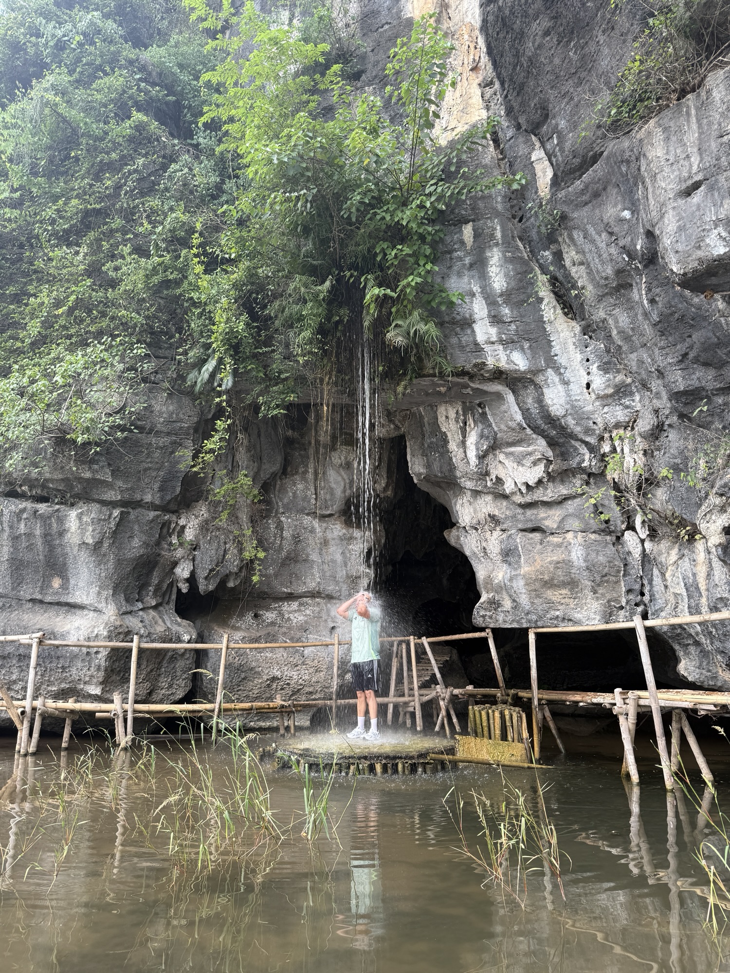 Baignade sous la cascade naturelle de Buffalo Cave près de Tam Coc, Ninh Binh