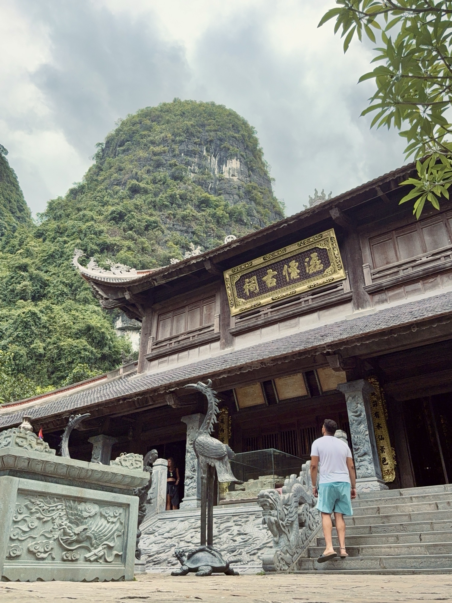 Temple au pied d'une montagne karstique pendant la balade en barque à Trang An, Ninh Binh
