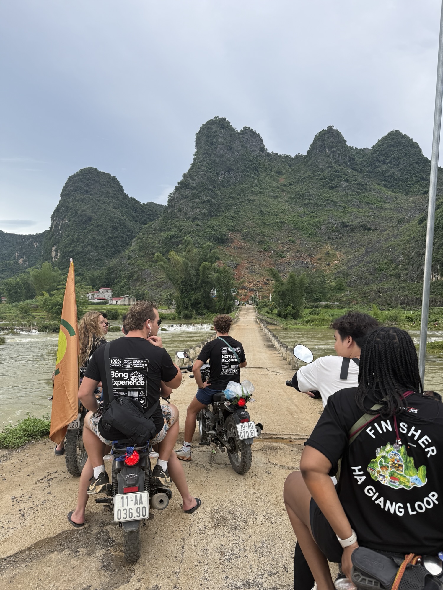 Groupe de voyageurs et guides locaux à moto sur une route de la boucle de Cao Bang