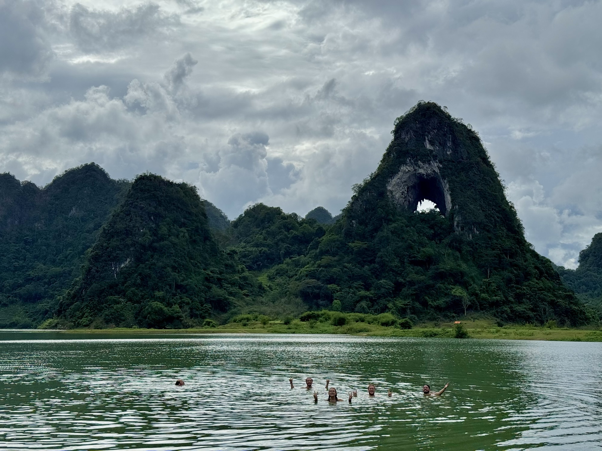 Baignade dans le lac devant la montagne de l'Oeil de Dieu en saison des pluies à Cao Bang